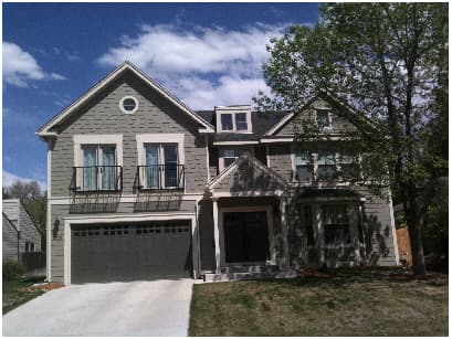 Newly built grey two-storey house with a front gable and garage